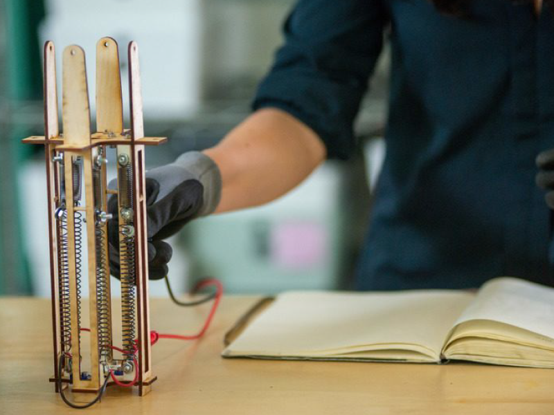 A person with a glove on their hand holds an adaptive architecture device