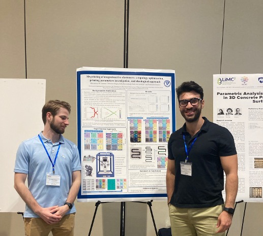 Two students stand in front of a poster at a poster session